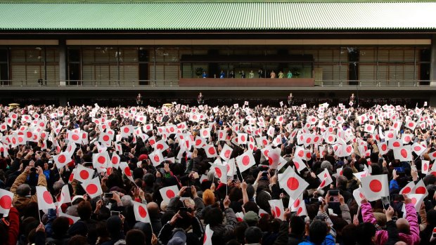 Well-wishers wave Japanese national flags as they shout "Long Live" to Emperor Akihito of Japan   during a New Year's public appearance at the Imperial Palace in Tokyo.