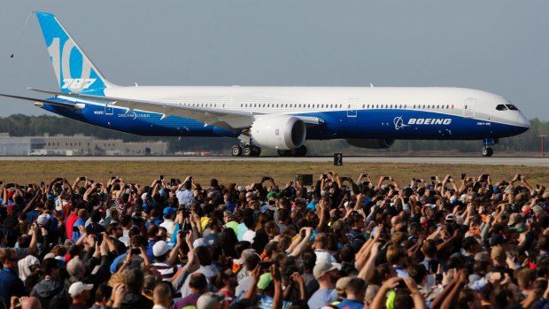 Boeing employees raise up their camera phones to record the first test flight of the new Boeing 787-10 Dreamliner as it taxis down the runway during a ceremony at Charleston International Airport in North Charleston.