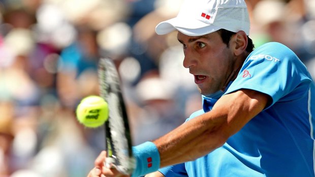 On top: Novak Djokovic returns a shot to Andy Murray.