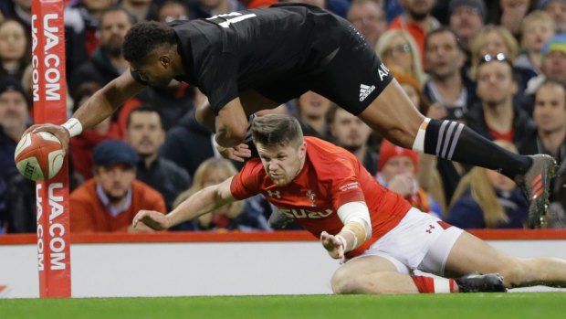New Zealand's Waisake Naholo, goes over the top of Wales's Steff Evans to score a try.