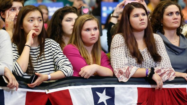 Young women listen to first lady Michelle Obama speak during a campaign rally for Democratic presidential candidate Hillary Clinton.