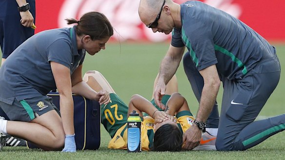 Sam Kerr receives treatement on the pitch.