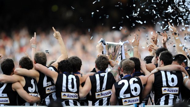 The 2010 Magpies are presented witht he premiership cup.