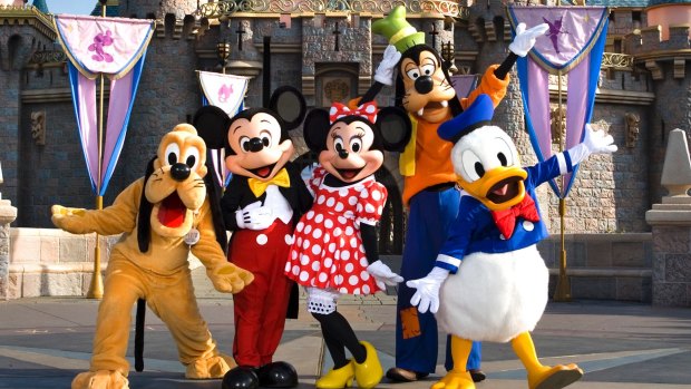 Classic Disney characters welcome visitors outside the Sleeping Beauty Castle at Disneyland.