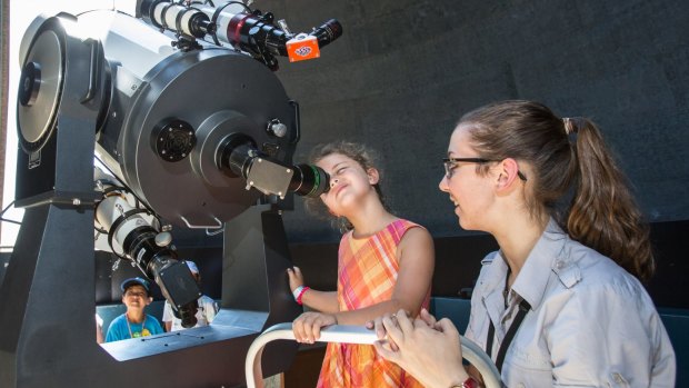 Aboriginal astronomy tour guide Kirsten Banks assists Tia, 6, at the Sydney Observatory this year.