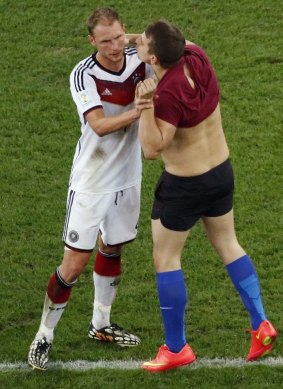 Prankster Vitaly Zdorovetskiy plants a kiss on the face of Benedikt Hoewedes.