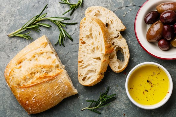 Fresh ciabatta with olive oil and olives.