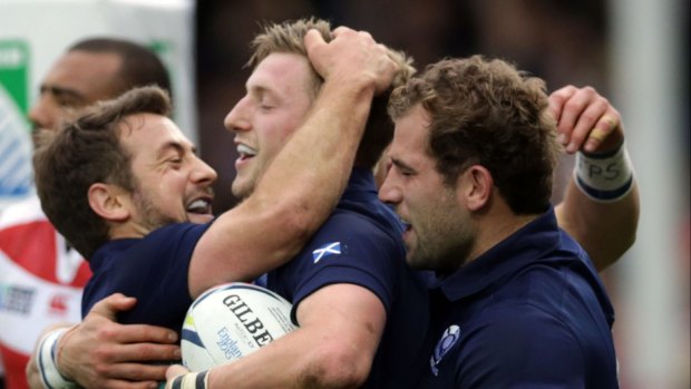 Scotland's Finn Russell, centre, celebrates scoring a try with teammates captain Greig Laidlaw, left, and Fraser Brown.