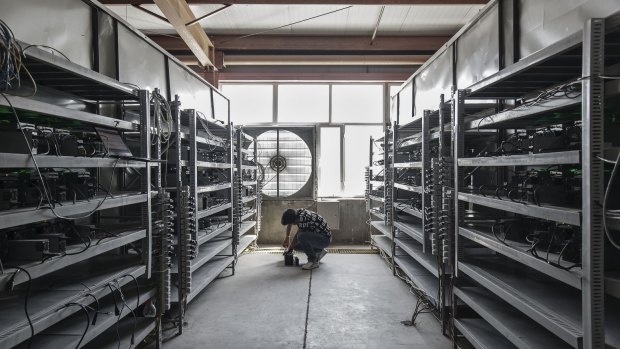 A technician inspects bitcoin mining machines at a mining facility in inner Mongolia.