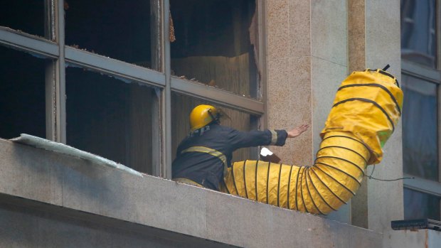 A fireman adjusts the vent to allow smoke to escape from the Resorts World Manila.