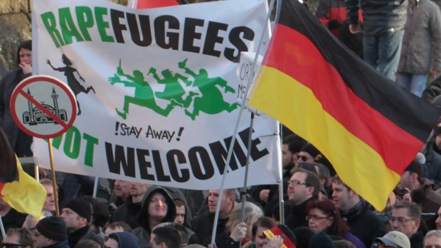 German demonstrators hold a sign "Rapefugees not welcome – Stay away!" as they march in Cologne after recent attacks on women.