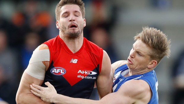 Hit and miss: North's Jack Ziebell tackles Melbourne's Jesse Hogan.