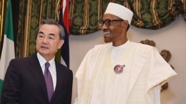 FILE- In this Wednesday, Jan. 11, 2017 file photo, Chinese Foreign Minister, Wang Yi, left, is welcomed by Nigeria President Muhammadu Buhari, at the Presidential Villa in Abuja, Nigeria. 