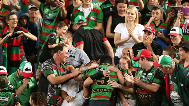 One big happy family: Issac Luke celebrates the grand final win, for which the hooker was suspended, with the Rabbitohs faithful.