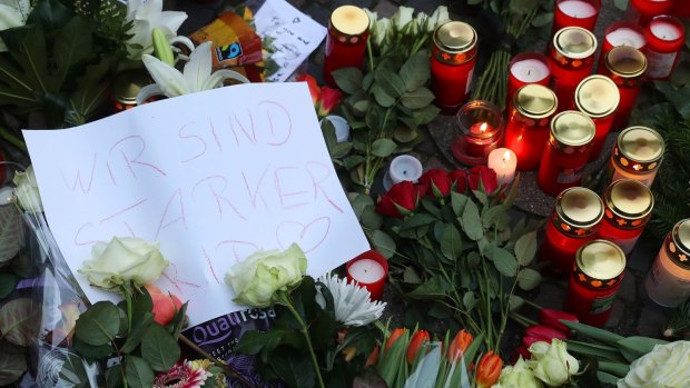 A message reading "We are stronger" sits amongst flowers near where the attack occurred.