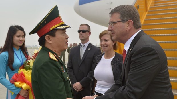 US Secretary of Defence Ash Carter and his wife Stephanie are met by an officer of the People's Army of Vietnam as they arrive at Cat Bi International Airport outside of Hanoi.