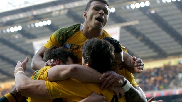 Will Genia, top, leaps on teammate Adam Ashley-Cooper, right, after scoring a try during their Rugby World Cup semi-final against Argentina at Twickenham in October last year.