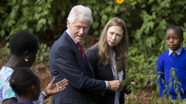 Former President Bill Clinton and daughter Chelsea Clinton are shown around a herb garden by pupils and staff of the Farasi Lane Primary School in Nairobi, Kenya.