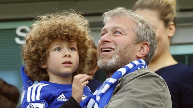 Family affair: Chelsea owner Roman Abramovich holds his son Aaron at full time. 