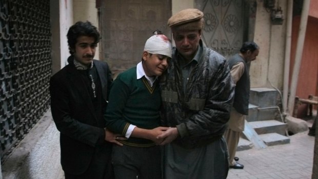 The uncle and cousin of injured student Mohammad Baqair, centre, comfort him as he mourns the death of his mother,  a teacher at the Peshawar school attacked by Taliban in December 2014.