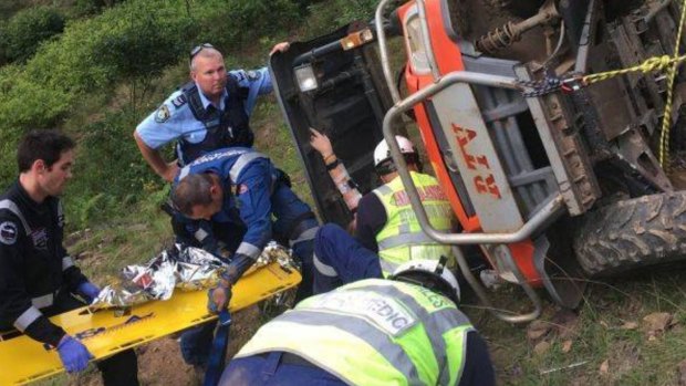 Emergency services help the woman as she remains trapped in the overturned quad bike. 