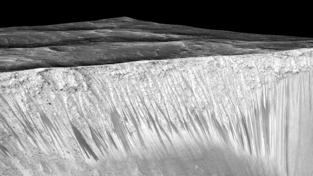 The dark streaks are about 100-metres long and flow down the side of a crater.