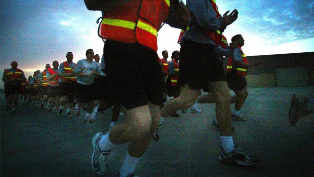 A US platoon sergeant leads his men and women in a run along one of the perimeter fences for their daily physical training in the early hours of the morning in Qatar in a file picture.