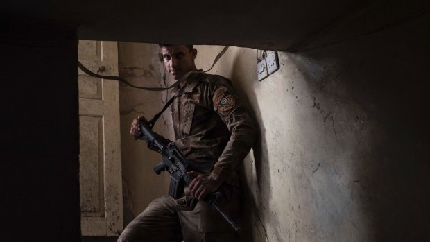 An Iraqi special forces soldier stands in a house near the frontline during fighting with Islamic State militants in the Old City of Mosul, Iraq, in June.
