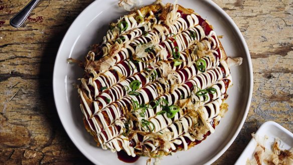 Okonomiyaki pancake decorated with Japanese mayonnaise and DIY okonomi sauce.