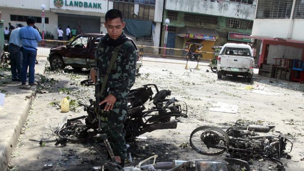 Ongoing terror campaign ... A Filipino soldier inspects the remains of motorcycles after bombings in Isabela, Basilan in southern Philippines in 2010.