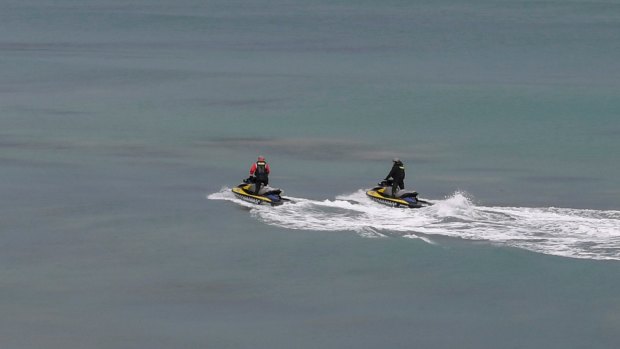 Police on jetskis search for evidence at the beach near Anglesea.