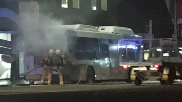 Firefighters extinguish a fire on a bus in George Street, Sydney, on Thursday night.