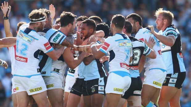 Wild bunch: Sharks and Titans players get up close and personal during Sunday's NRL clash.