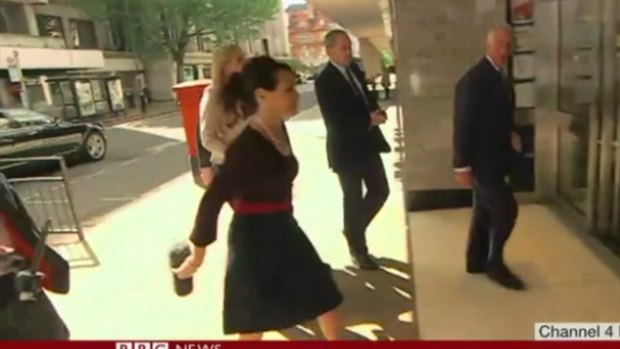 Prince Charles' top press adviser, Kristina Kyriacou, walks away with the protective covering of reporter Michael Crick's microphone.