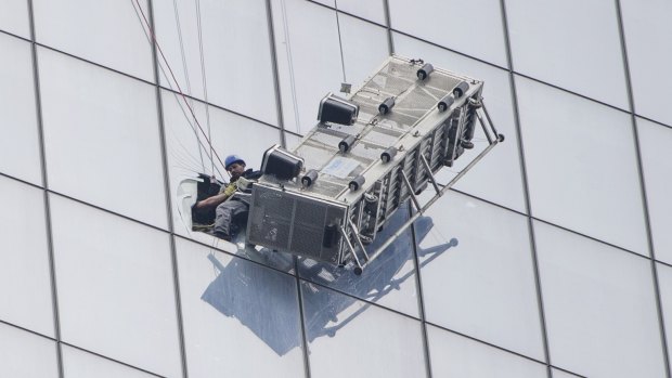 One of two window-washers is pulled to safety.