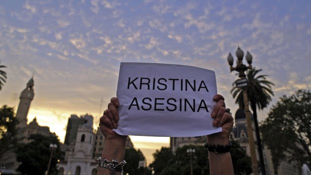 A woman holds a sign reading "Kristina assassin" during a demonstration at Mayo square, in Buenos Aires. 