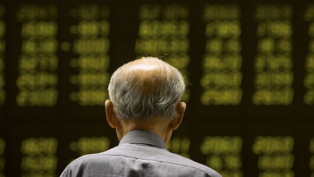 A Chinese investor monitors stock prices at a brokerage house in Beijing.