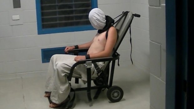 Dylan Voller is hooded and strapped to a restraining chair.