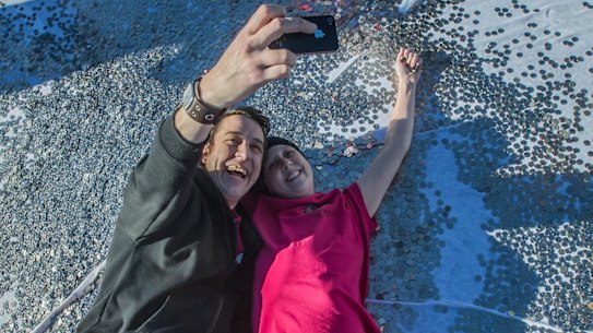 Connie and Samuel Johnson luxuriate in a sea of 5c coins for the Love Your Sister big heart project in May.