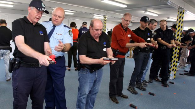 Actor Roy Billing learns how to load a gun during the NSW Police training program. 