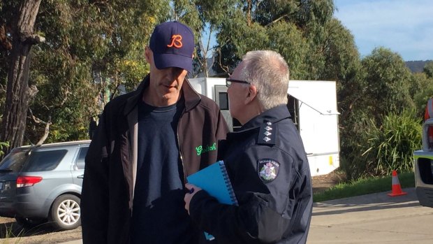 David Curry speaks to a police officer at Aireys Inlet, where his wife Elisa went missing.