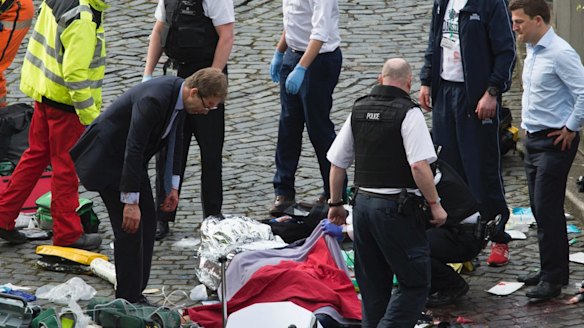 Mr Ellwood, left, is shown leaning over the officer's body.