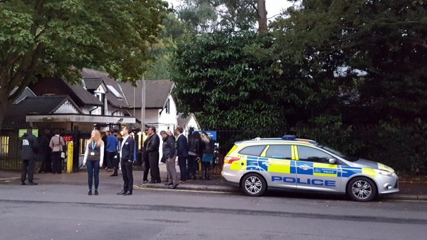 Police and evacuated visitors stand outside London Zoo after a gorilla escaped in London.