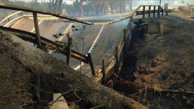 The intense heat of the bushfire has caused the Samson Brook bridge asphalt to buckle and collapse. Photo: Nine News Perth via WA Today 7th January 2016