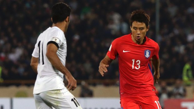 South Korea's Koo Ja Cheol (right) tries to dribble past Iran's Vahid Amiri during their World Cup group A qualifying match.