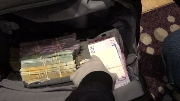 Police allegedly found large amounts of foreign currency and a gun in a bag during the raid.