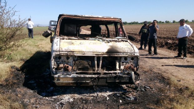 Mexican authorities inspect a burnt-out van suspected to belong to a couple of Australian tourists missing for more than a week, in Sinaloa, Mexico.