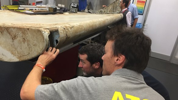 Malaysian and Australian investigators examine the piece of aircraft debris found on Pemba Island off the coast of Tanzania.