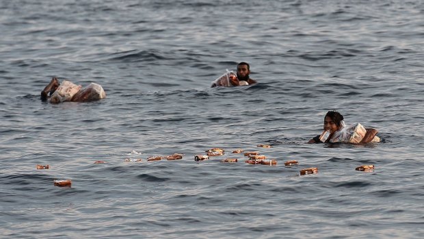 Migrants collect desperately needed food dropped by a Thai army helicopter.