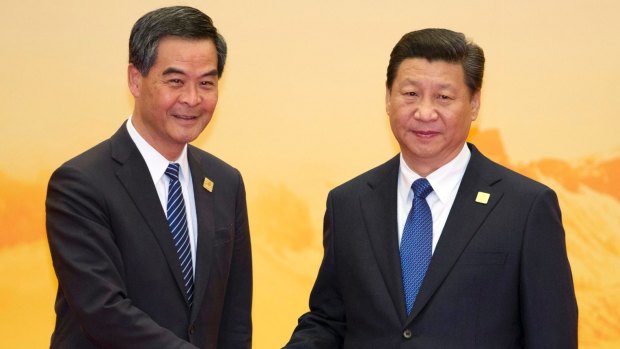 Hong Kong's Chief Executive Leung Chun-ying, left,  shakes hands with Chinese President Xi Jinping. Democracy protesters continue to call for him to step down.